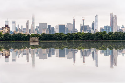 Reflection of buildings in river against sky