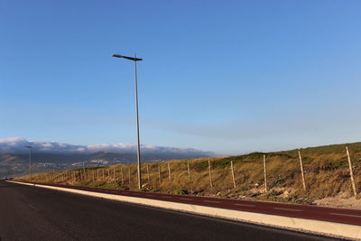 Road by mountains against clear blue sky