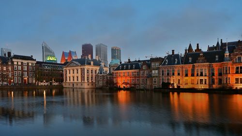 Reflection of buildings in city at dusk