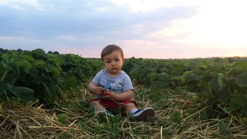 Boy smiling on field against sky