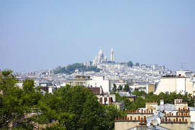 View of buildings in city against clear sky