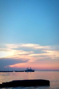 Boats in sea at sunset