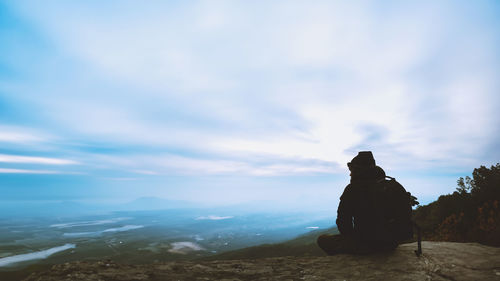 Silhouette man standing on mountain against sky