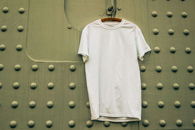 Close-up of t-shirt hanging against patterned wall