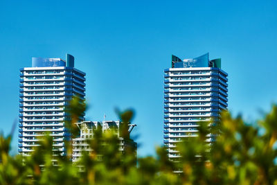 Low angle view of buildings against clear blue sky