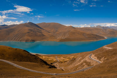 Scenic view of lake and mountains against blue sky