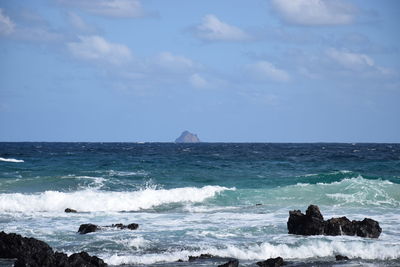 Scenic view of rocks in sea against sky