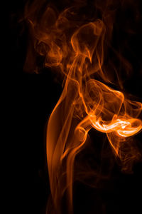 Close-up of orange smoke against black background