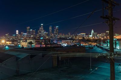 Illuminated cityscape against sky at night