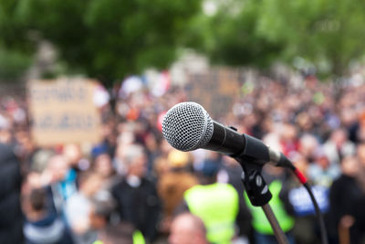 Close-up of microphone against crowd in city