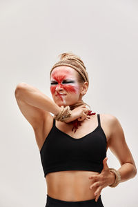 Portrait of young woman standing against white background