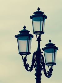 Low angle view of gas lights against sky