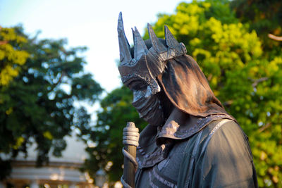 Side view of man statue against blurred trees