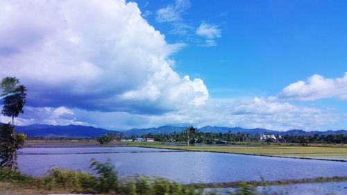 Scenic view of lake against cloudy sky