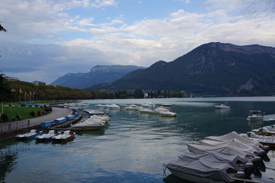 Boats in sea against cloudy sky