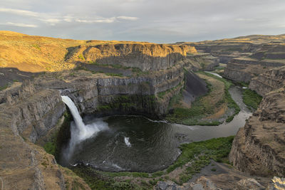Scenic view of waterfall against sky
