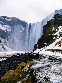 Scenic view of waterfall against sky