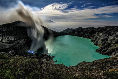 Scenic view of waterfall in sea against sky