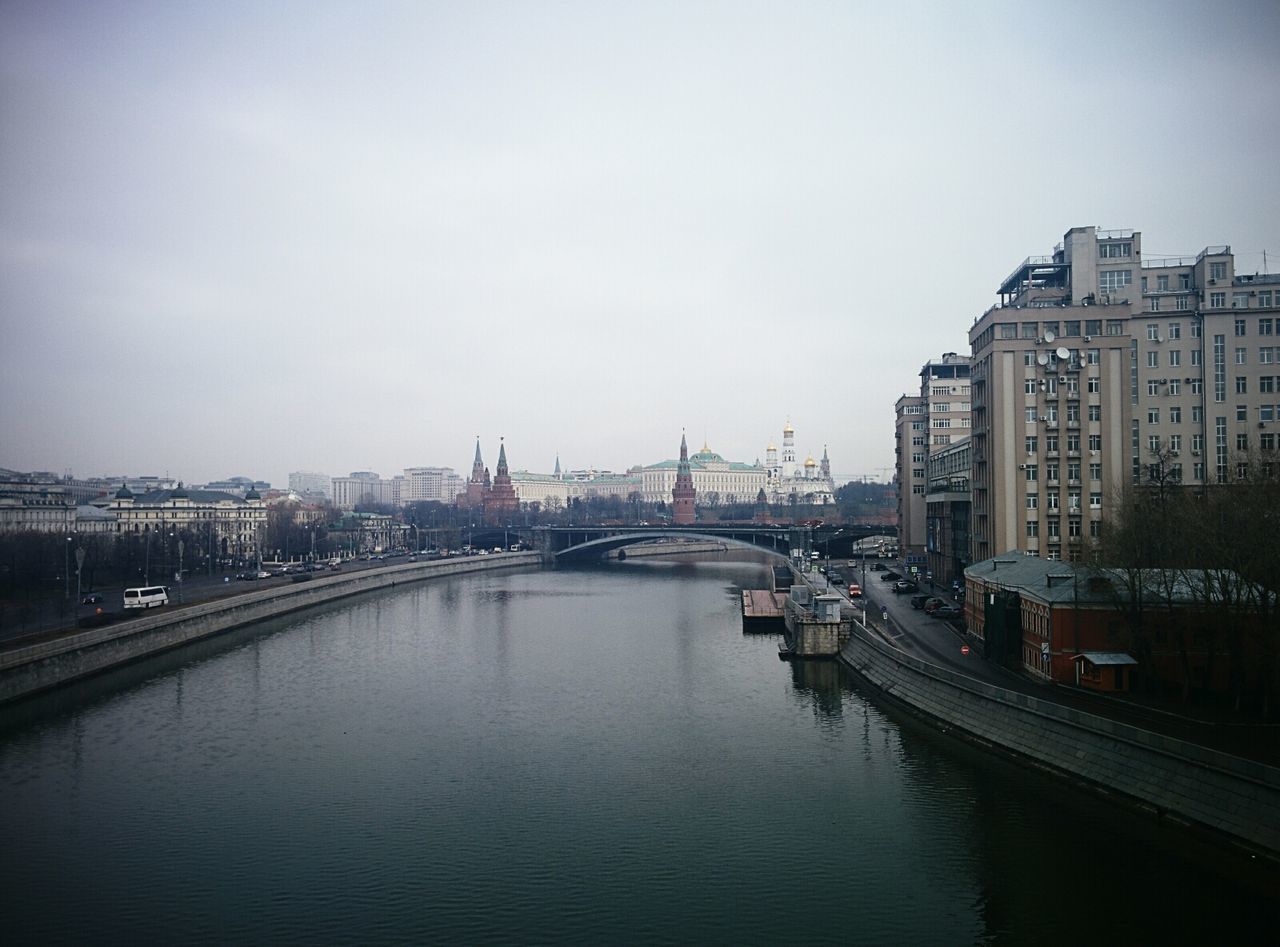 architecture, built structure, building exterior, water, waterfront, river, city, transportation, sky, nautical vessel, copy space, connection, bridge - man made structure, canal, clear sky, mode of transport, harbor, reflection, travel destinations, outdoors