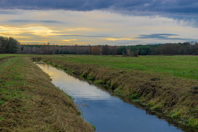 Scenic view of agricultural field against sky during sunset