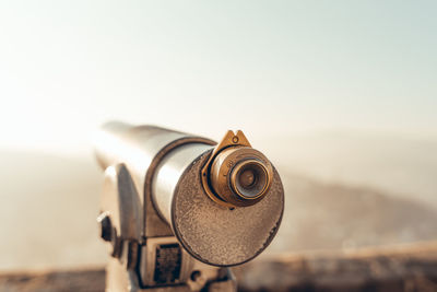 Close-up of coin-operated binoculars against sky