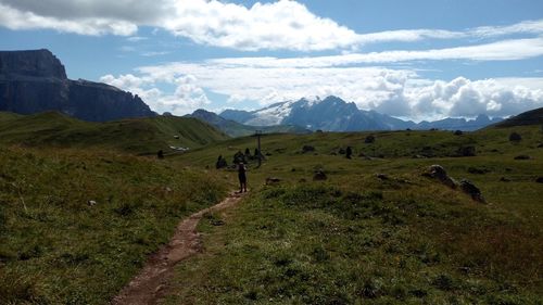 Scenic view of green landscape and mountains against sky