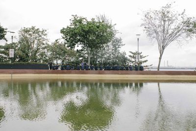 Swimming pool by lake against sky