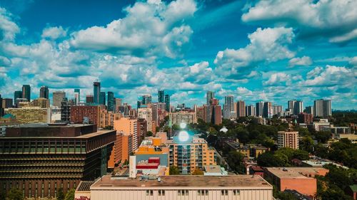 View of cityscape against cloudy sky