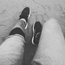 Low section of man standing on sand