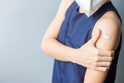 Midsection of woman holding hands against white background