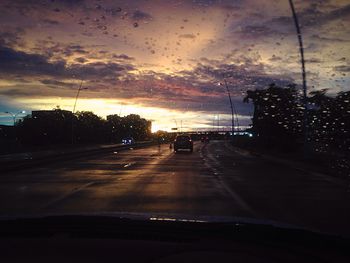 Car on street against dramatic sky