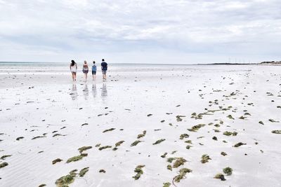 People on beach against sky