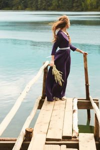 Woman standing on pier at lake