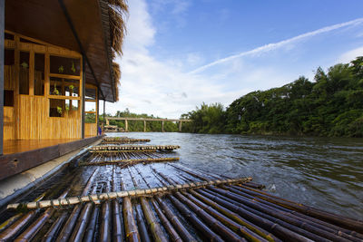 View of house by river against sky