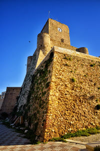 Low angle view of historic building against blue sky