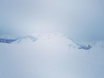 Aerial view of snowcapped mountain against clear sky