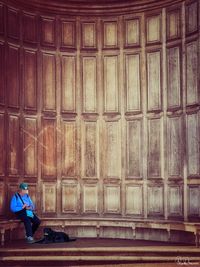 Full length of woman sitting outside building