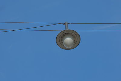 Low angle view of light bulb against clear blue sky