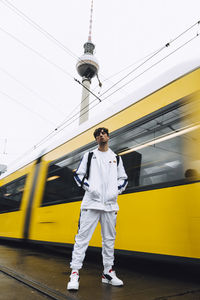 Low angle view of man standing on train against sky