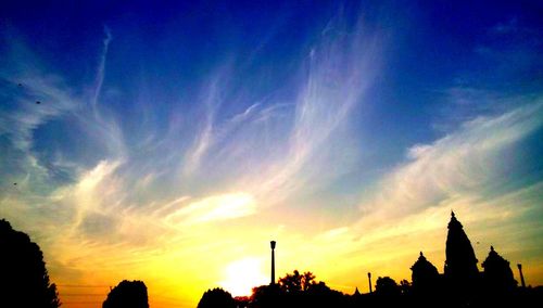 Silhouette of building against cloudy sky