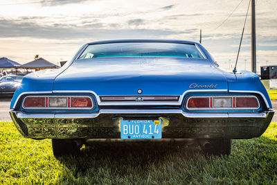 Vintage car on field against sky