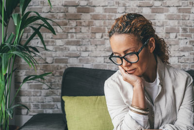 Close-up of woman looking down sitting on sofa