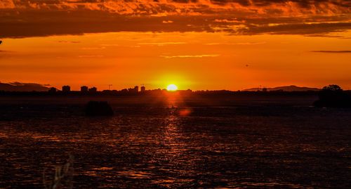 Scenic view of sea against orange sky