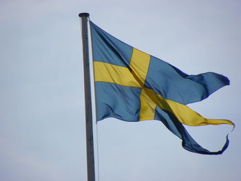 Low angle view of swedish flag against sky