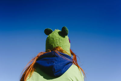 Rear view of woman against blue sky
