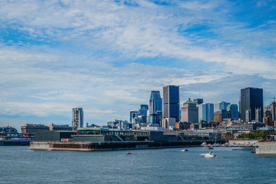 Sea by cityscape against sky