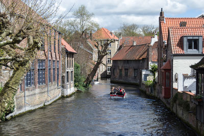 River amidst houses and buildings against sky