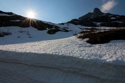 Scenic view of snow covered mountains against blue sky