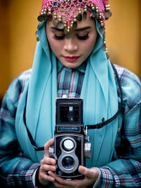 Beautiful asian female posing with a retro camera