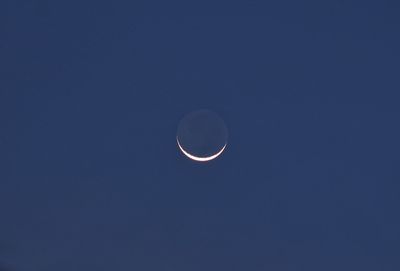 Low angle view of moon against clear blue sky